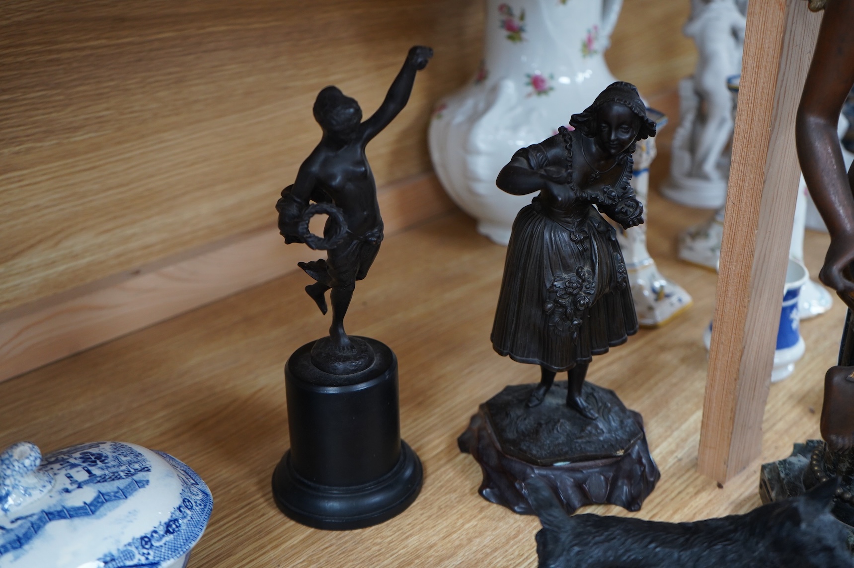 A bronzed spelter angel on column plinth, 38cm high, two other figures, a model of a dog on a book, a letter clip and an oval classical plaque. (6).